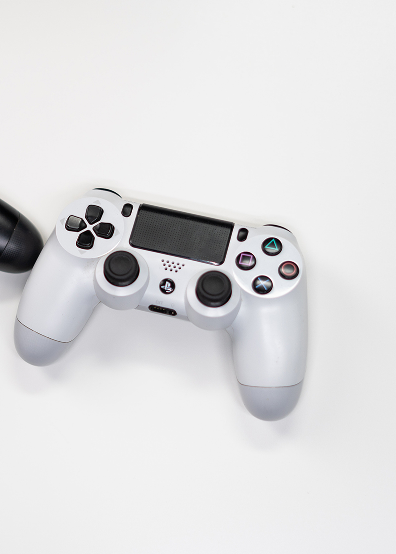 A white and black video game controller on a white background. 