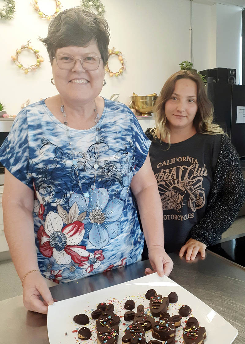 Two women with a plate of finished easter chocolates