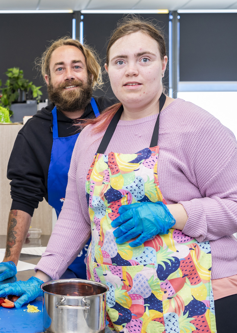 Two people standing in a kitchen