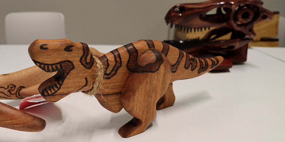 A dinosaur toy made out of timber