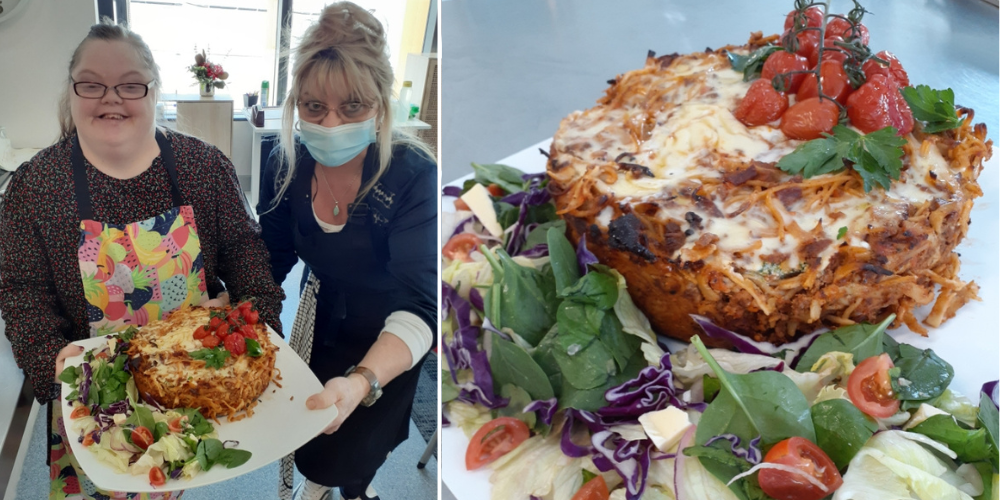 There are two photos side by side. The first photo shows two women from CPL Hope Island holding a plate with the Ricotta and Spinach Stuffed Pie on it, complete with salad. On the next photo is a close up image of the same Ricotta and Spinach Stuffed Spaghetti Pie topped with melted cheese, mini tomatoes and a side of green salad