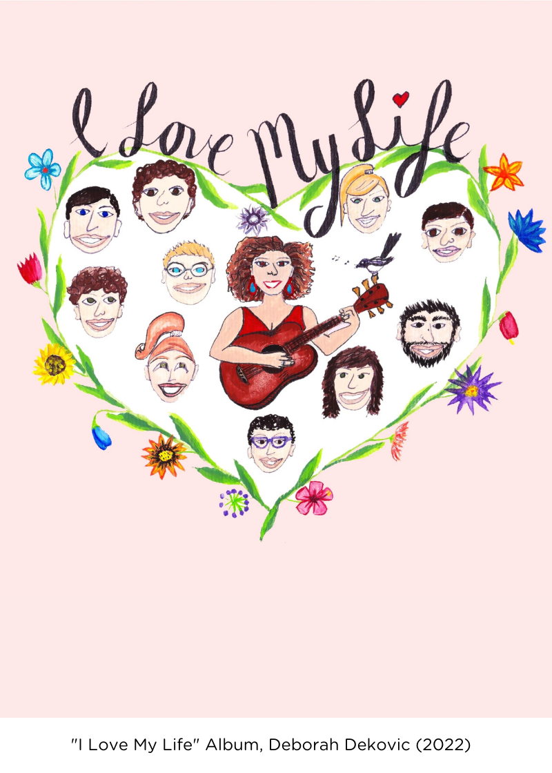 An illustration of a heart where the outline is made by a vine of flowers. Inside the heart is a variety of different faces, with a woman in the middle with a guitar. Above the heart is the words handwritten, "I Love My Life". At the bottom is a white box which has the artwork credit: "I Love My Life Album - by Deborah Dekovic (2022)".